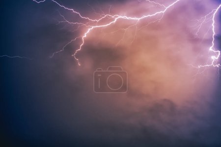 Photo for A shot of violent lightning in the night sky with spooky clouds - Royalty Free Image