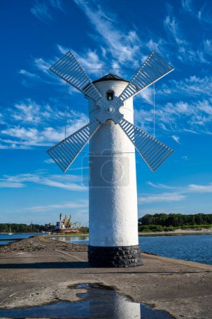 Téléchargez les photos : Vue du moulin à vent de Swinoujscie sur la mer Baltique sous un ciel bleu - en image libre de droit