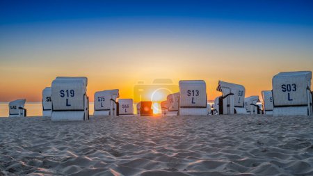 Téléchargez les photos : Lever de soleil sur la plage au bord de la mer Baltique avec chaises longues sur l'île d'Usedom - en image libre de droit