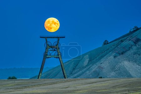 Photo for The moon above the winding tower at the spoil tip at the blue hour - Royalty Free Image