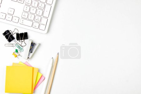 Photo for Top view of modern white office desk with computer keyboard, blank notebook page and other equipment on white background. Workspace concept, workspace management style, business design space with copy - Royalty Free Image