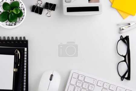 Foto de Composición plana con ratón de ordenador, accesorios de oficina, cuaderno y papelería sobre fondo blanco con espacio para el texto - Imagen libre de derechos