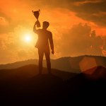 Silhouette of a man holding a trophy cup. success concept.
