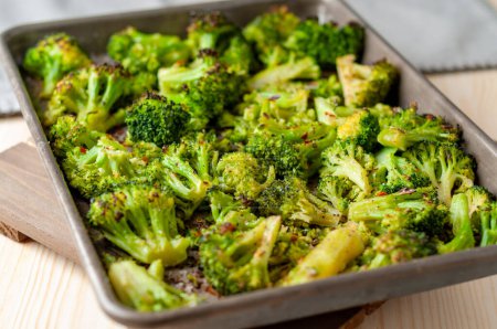 Roasted broccoli on a sheet pan with red pepper flakes