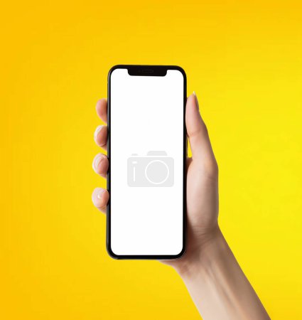 Foto de Smartphone de mano femenina con pantalla en blanco sobre fondo amarillo. Burla. - Imagen libre de derechos