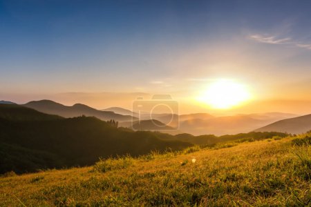 Foto de Pastizales en las montañas al atardecer con rayos de sol. - Imagen libre de derechos