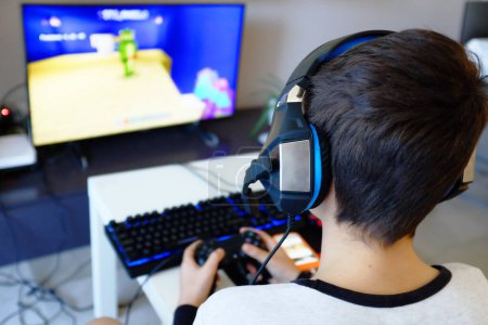 Téléchargez les photos : Jeune garçon jouer à des jeux informatiques - en image libre de droit
