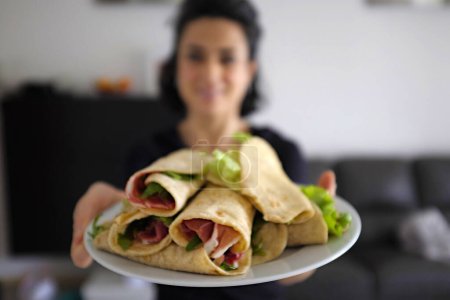 Foto de Manos femeninas sosteniendo un plato con una piadina, comida saludable, alimentación saludable, dieta y concepto de dieta - Imagen libre de derechos