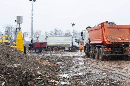 Déposer les déchets municipaux. Travailleurs avec camions et bulldozers au travail dans les décharges de stockage des déchets.