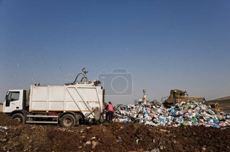 Foto de Residuos municipales. Trabajadores con camiones y excavadoras en el trabajo en vertederos de almacenamiento de residuos. - Imagen libre de derechos
