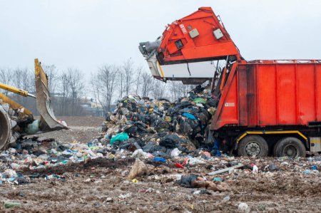Déposer les déchets municipaux. Travailleurs avec camions et bulldozers au travail dans les décharges de stockage des déchets.