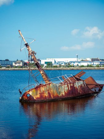 Téléchargez les photos : Vieille coque rouillée de la liste des bateaux dans l'eau à Alfred dock Birkenhead Wirral UK - en image libre de droit