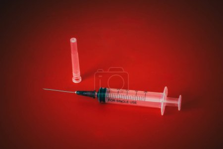 Photo for Syringe and needle isolated on red background - Royalty Free Image
