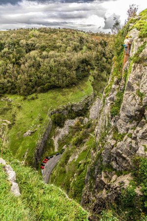 View from cliff edge of Cheddar Gorge and mountain climber in Somerset.