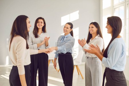 Photo for Happy women colleagues shaking hands on meeting in office, celebrating success, making a deal or business achievement. Female coworkers team applaud congratulating their partners on job well done. - Royalty Free Image