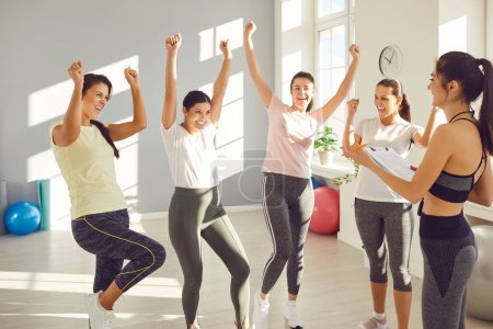 Photo for Group of young sporty girls in happy yes pose with coach, fitness club sportswomen holding group exercise, happy female team workout to improve, attractive active friends, sport instructor together - Royalty Free Image