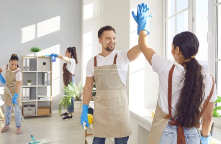 Photo for Team of service cleaning staff, home and office cleaners, giving high five with smile. Unity and teamwork during housecleaning, exchanging high five, positive spirit of collective work. - Royalty Free Image