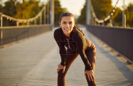 Photo for Portrait of happy smiling sporty woman looking at camera after doing sport fit exercises in the city park outdoors. Workout in nature, sport, fitness training and healthy lifestyle concept. - Royalty Free Image