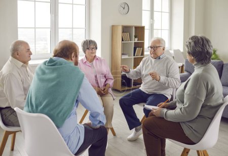 Téléchargez les photos : Groupe de personnes âgées lors d'une séance de thérapie en maison de retraite. Hommes et femmes âgés assis en cercle et ayant une conversation et discuter de certains problèmes ensemble. Concept de psychothérapie. - en image libre de droit