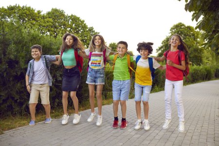 Photo for Happy school kids having fun together. Bunch of joyful little school friends playing games outside. Group of cheerful, overjoyed children in comfortable casual clothes jumping on a park path - Royalty Free Image