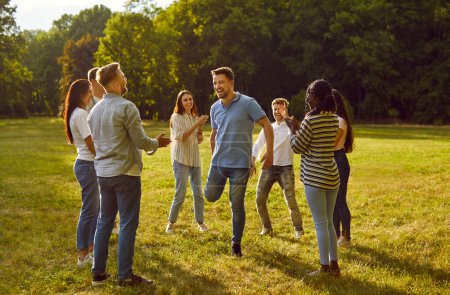Foto de Retrato de un grupo de jóvenes felices emocionados amigos o colegas divirtiéndose juntos en la naturaleza en el parque. Estudiantes felices jugando juegos al aire libre en un día soleado de verano. - Imagen libre de derechos