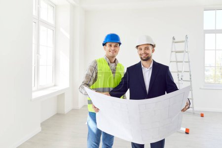 Photo for Male builder and engineer happy holding project paper plan for apartment repair, renovation, analyzing real estate market finance, construction restore investment, professionals wearing hardhats - Royalty Free Image