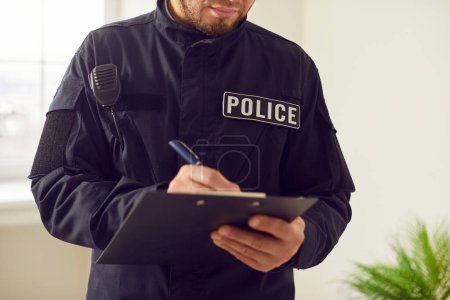Photo for Policeman, officer police man in uniform writing crime reports form, gathering prosecution evidence close up. Emergency service worker busy filling official papers, information - Royalty Free Image