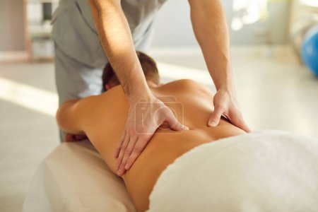 Photo for Close-up of a man masseur hands applying therapeutic techniques to a patient back in massage salon, effectively relieving tension and promoting healing through skilled massage therapy. - Royalty Free Image
