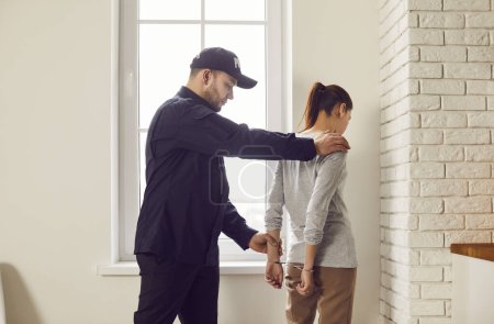 Photo for Policeman is arresting a woman, putting handcuffs on her. The arrest is part of law enforcement police procedures related to a crime, with the woman being taken into custody as a suspect or criminal. - Royalty Free Image