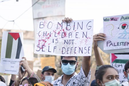Photo for Guy holding a "bombing children is not self defense" in a protest - Royalty Free Image