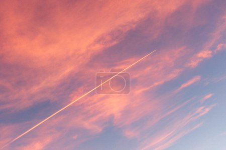 Photo for Discover breathtaking stock photography of a picturesque, azure and pink sunset sky, adorned with a mesmerizing diagonal contrail. Perfect for your creative projects, this stunning image captures the beauty of nature's palette. Ideal for agencies see - Royalty Free Image