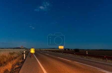 Photo for Elevate your creative projects with our striking stock photo featuring a mesmerizing nighttime highway view, accentuated by a blurred human figure. Perfect for agencies seeking impactful visuals, this high-quality image captures the essence of advent - Royalty Free Image