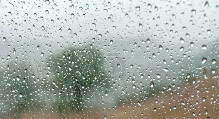 Photo for Explore our stunning abstract photograph of rain-kissed glass, revealing hints of a serene landscape. Perfect for stock agencies, this high-quality texture captures the beauty of raindrops, creating a versatile backdrop for various creative projects. - Royalty Free Image