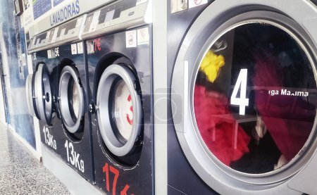Photo for Discover the essence of modern urban living with our captivating abstract photograph of well-worn washing machines in a bustling laundromat. These machines embody both the cosmopolitan lifestyle and the sustainable living trend, showcasing the commun - Royalty Free Image