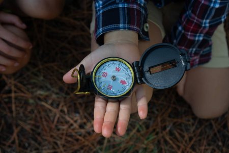 Kompass auf Kinderhand von oben gesehen