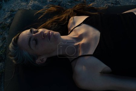 Photo for Woman lying meditating on her yoga mat - Royalty Free Image