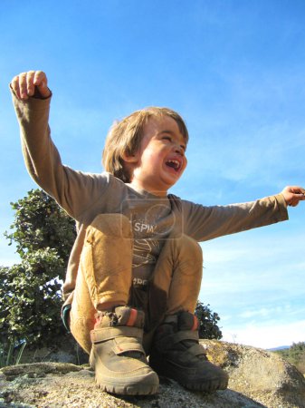 Photo for Little boy full of dirt very happy smiling and with his arms up in nature - Royalty Free Image