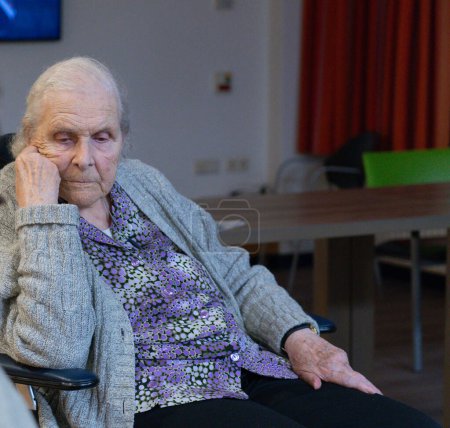 Photo for Elderly woman in a wheelchair in a nursing home pensive - Royalty Free Image