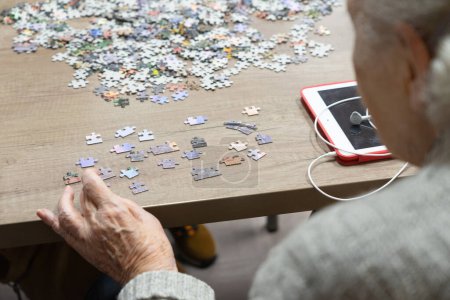 Téléchargez les photos : Femme âgée faisant un puzzle - en image libre de droit