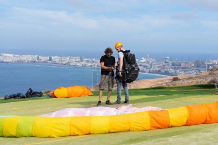 Man learning to paraglide with the help of a paragliding expert