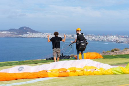 Paragliding instructor teaching a student how to use the controls of a paraglider