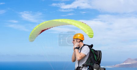 Paraglider putting on his helmet to paraglide