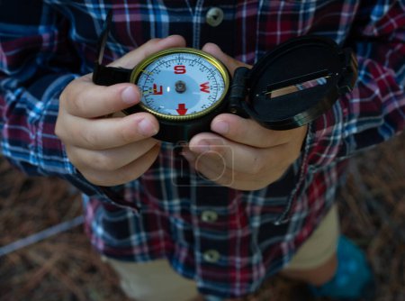 Child's hands with a compass in nature
