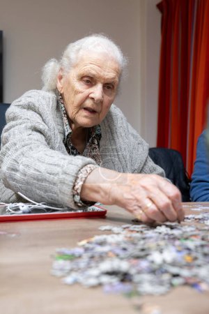 Téléchargez les photos : Femme âgée faisant un puzzle - en image libre de droit