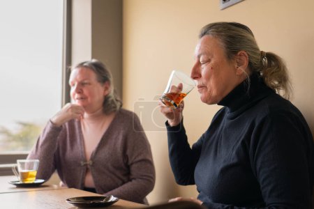 Zwei ältere Freundinnen in einem Café beim Tee