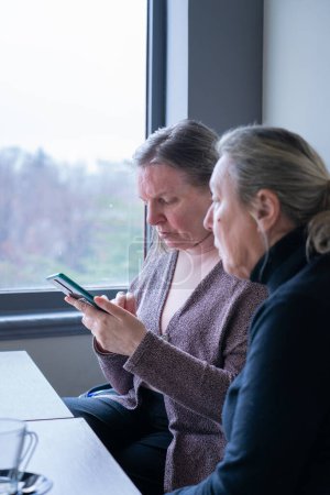 Zwei Seniorinnen schauen aufs Handy