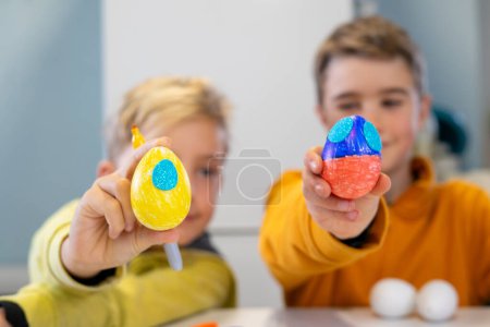 Kinder zeigen ihre verzierten Ostereier
