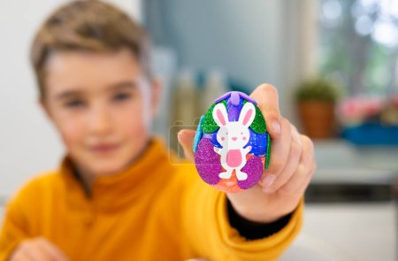 Child showing an Easter egg decorated by him