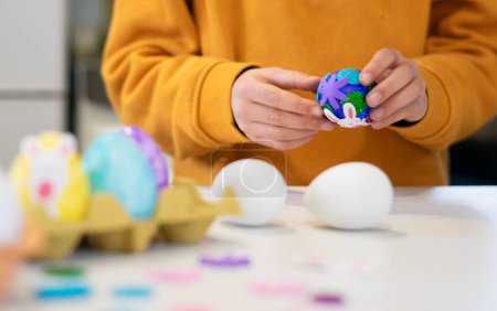 Child's hands decorating an Easter egg
