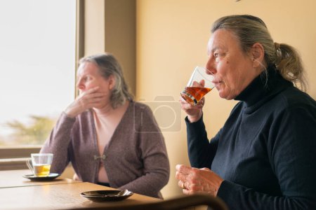 Zwei reife Frauen genießen zusammen Tee